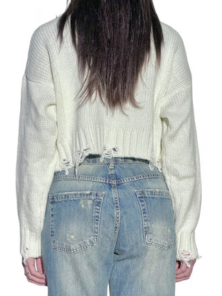 Pull cropped latte a collo alto con rotture sul fondo